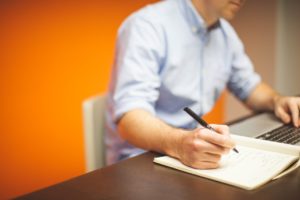 Man working with a laptop and notebook